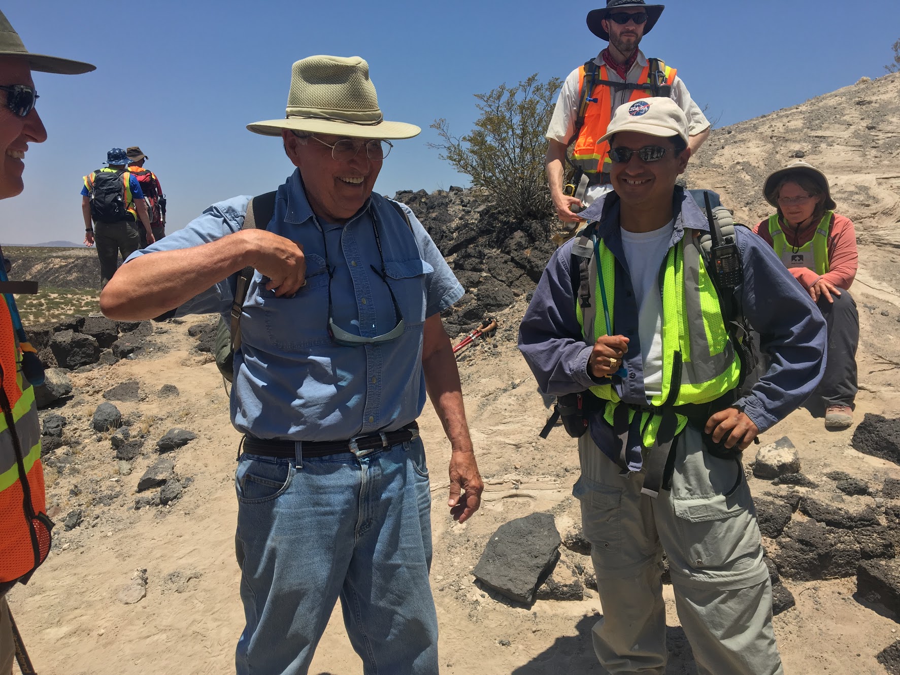 Astronaut Barry "Butch" Wilmore, Astronaut Jack Schmitt, discuss field geology with Prof. Jose Hurtado. Jacob Bleacher in background (black hat).